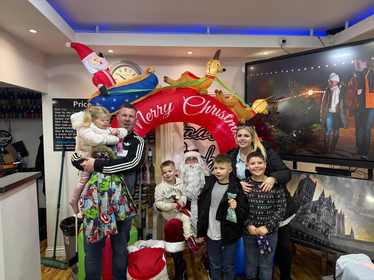 A family with Santa under the Christmas arch inside Fade Barbers